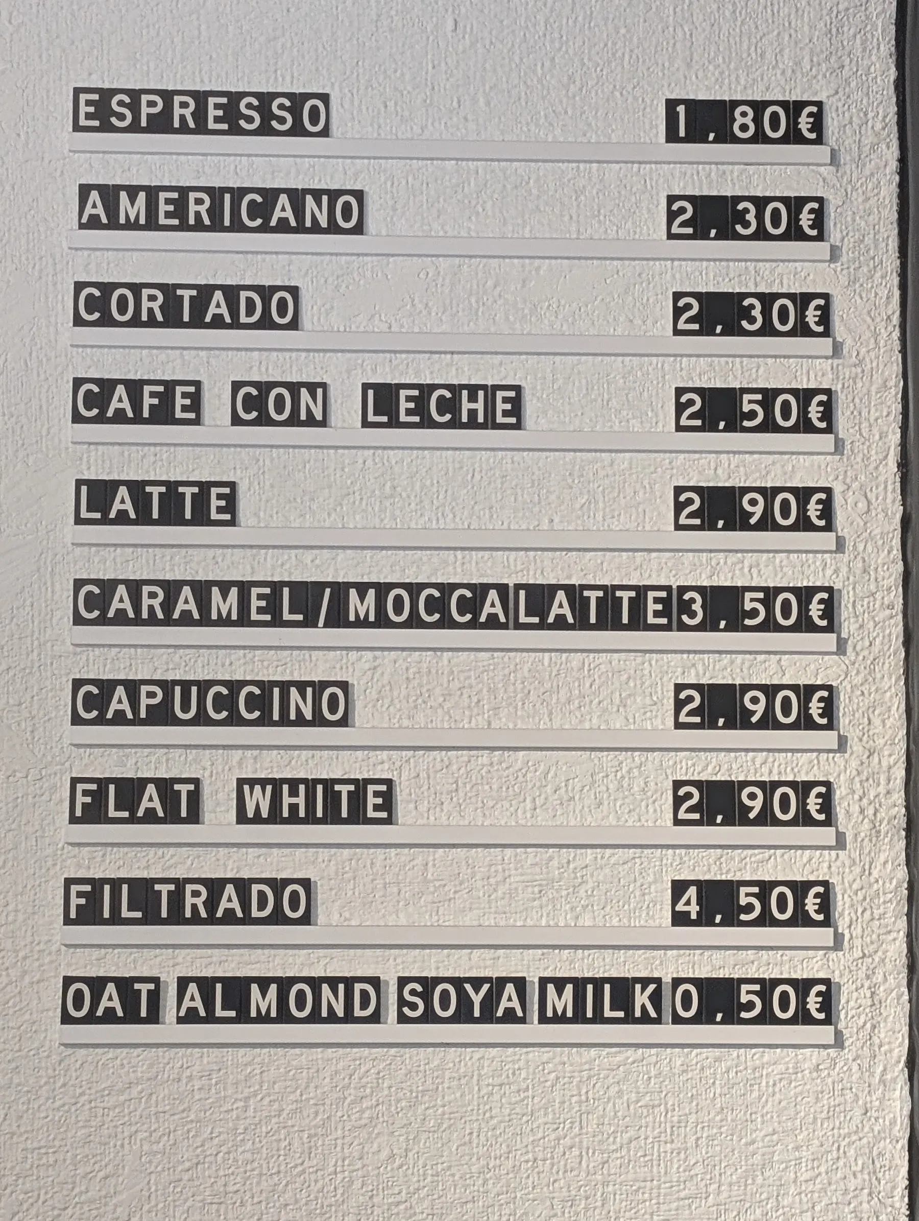 La pizarra de letras de la pared con los cafés y sus precios